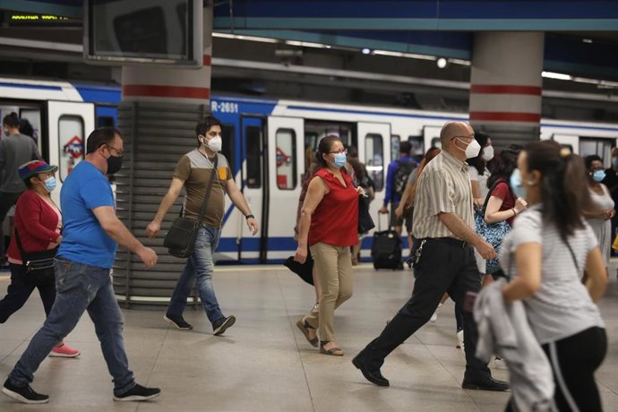 Pasajeros con mascarilla salen de un vagón en la estación de Metro de Atocha, en Madrid (España), a 22 de junio de 2020.