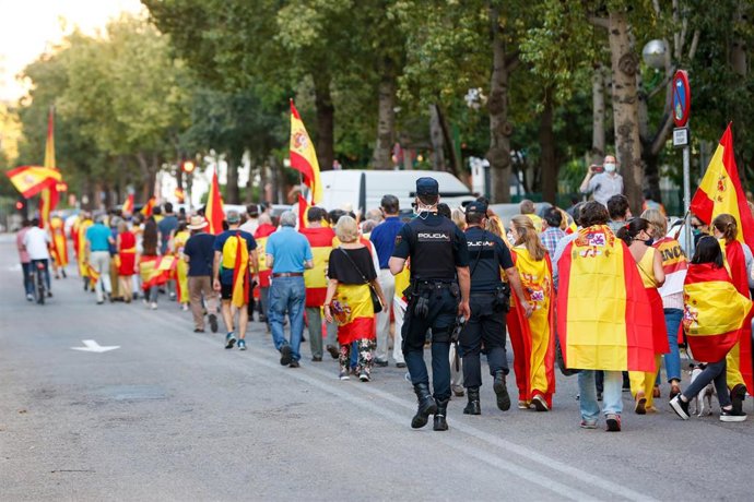 Manifestantes por el barrio del Polvenir con  la bandera española en  una concentración contra el Gobierno central por su gestión ante la pandemia 