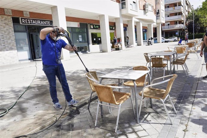Un trabajador desinfecta la terraza de un restaurante antes de reabrir sus puertas en la desescalada ante la crisis sanitaria del Covid-19. En Valdemoro, Madrid, (España), a 23 de mayo de 2020.