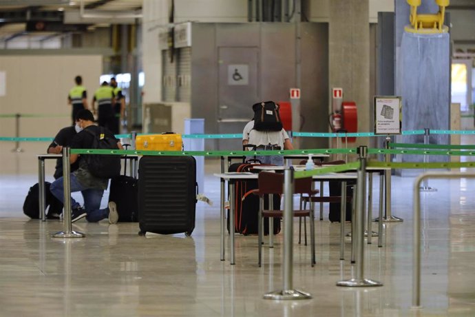 Pasajeros procedentes de Londres rellenan un formulario a su llegada al Aeropuerto de Madrid-Barajas Adolfo Suárez como medida de control de los casos sospechosos de coronavirus. En Madrid (España), a 24 de junio de 2020.
