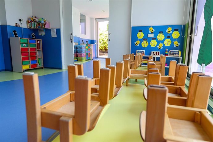 Mesas y sillas recogidas en un aula de un Centro de Educación Infantil , foto de archivo