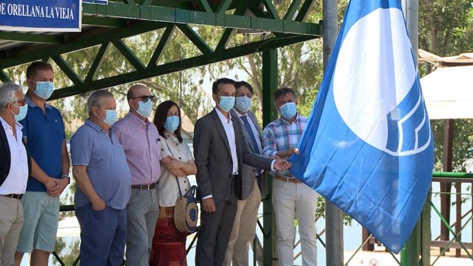 Izado de la bandera azul de la Playa Costa Dulce de Orellana la Vieja (Badajoz) y de su puerto deportivo.