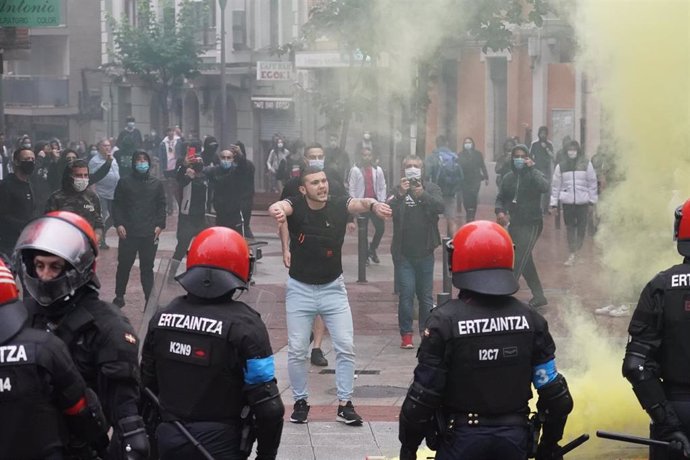 Agentes de la Ertzaintza cargan contra un grupo de radicales que intentan boicotear un mitin del presidente de Vox, Santiago Abascal, en Sestao.
