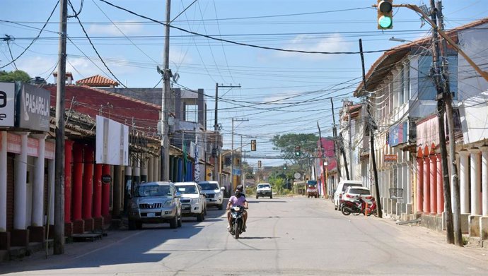 31 May 2020, Bolivia, Trinidad: Two men ride a motorcycle down an almost empty road amid a a five-day curfew imposed to curb the spreading of coronavirus. Photo: Diego Valero/ABI/dpa
