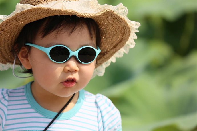 Una niña con gafas de sol, protección solar, radiación solar