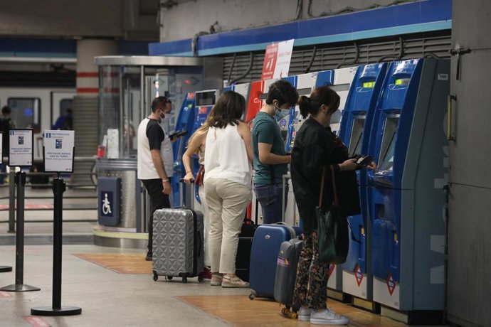 Varias personas recargan sus abonos de metro en la estación de Metro de Atocha, en Madrid (España), a 22 de junio de 2020. 