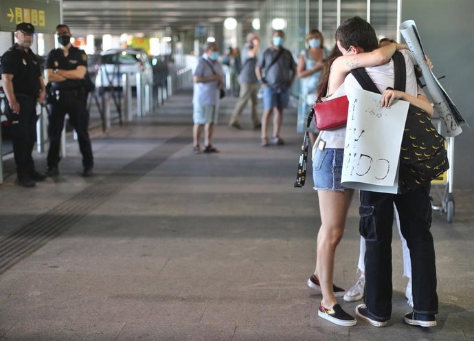 Dos jóvenes se abrazan en la Terminal T1 del Aeropuerto Adolfo Suárez Madrid-Barajas el día de su apertura