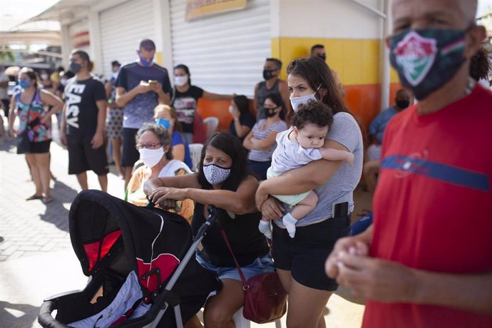 Personas hacen fila para hacerse la prueba del coronavirus durante un examen masivo en Río de Janeiro (Brasil) a 27 de junio de 2020