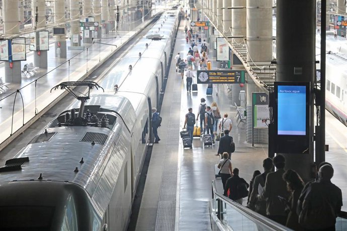 Varios pasajeros acceden al andén por una cinta mecánica en la estación Madrid-Puerta de Atocha