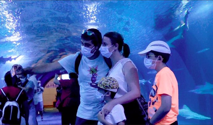 Una familia de visitantes en el túnel de tiburones