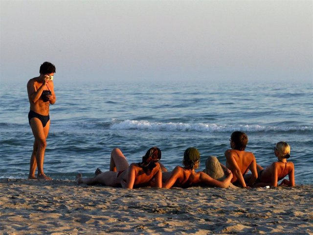 Sunbathers pose for a picture on the beach of Yalta August 18, 2003 in Crimea, Ukraine.