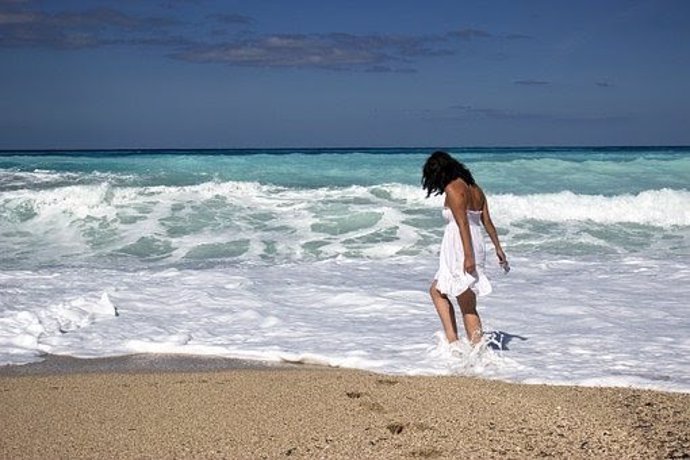 Una mujer caminando por la playa