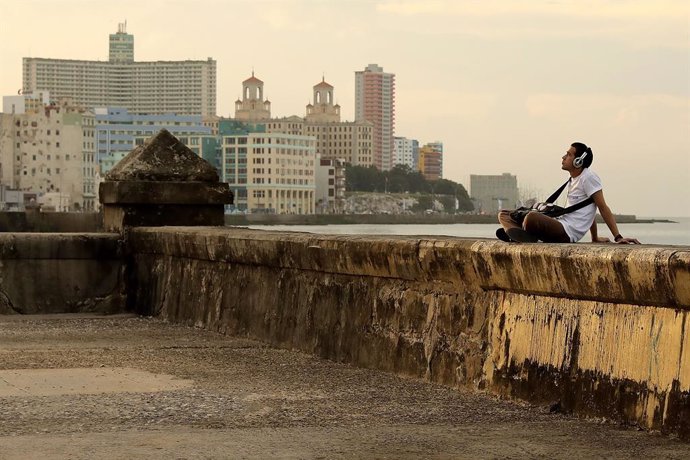 Un joven escucha música en el Malecón de La Habana