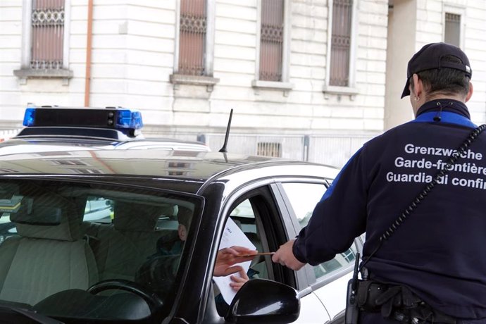 Un agente controla los documentos en un paso fronterizo entre Suiza e Italia