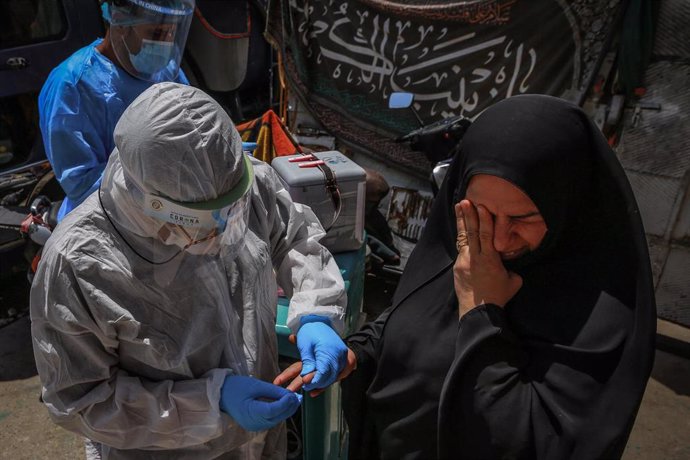 Un trabajador sanitario de Irak hace una prueba a una mujer para determinar si tiene coronavirus