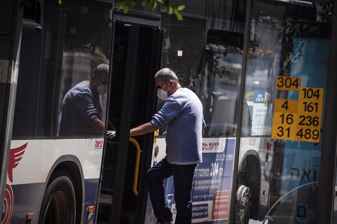 Un hombre con mascarilla se sube a un autobús durante la pandemia de coronavirus en Israel