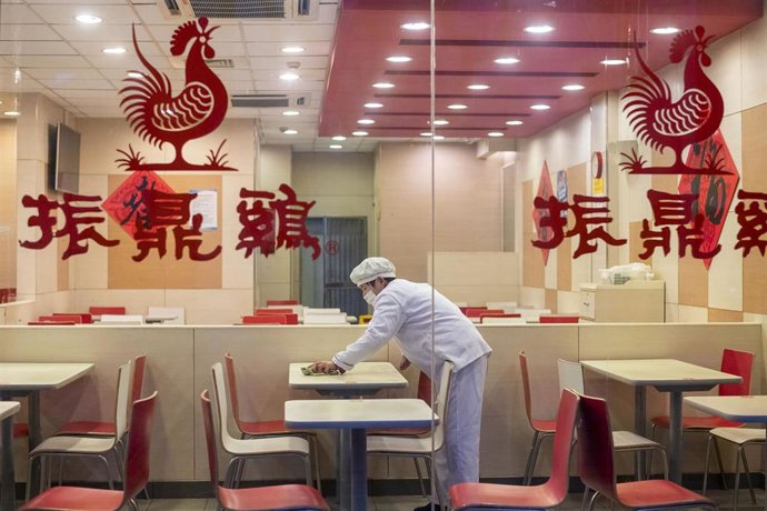 Un trabajador de un restaurante de Shanghái limpia una de las mesas del establecimiento durante la primera etapa de las medidas de confinamiento decretadas para frenar el avance de la COVID-19.
