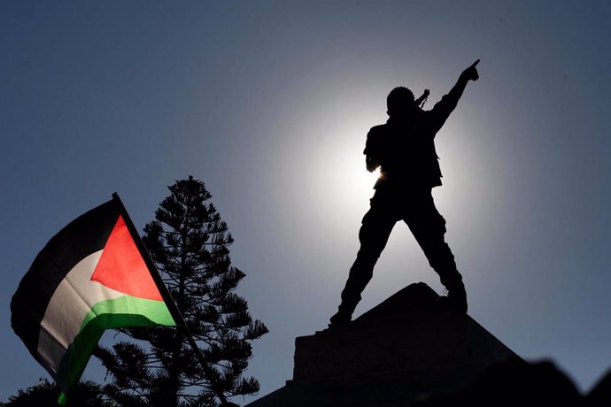 Un manifestante y una bandera palestina