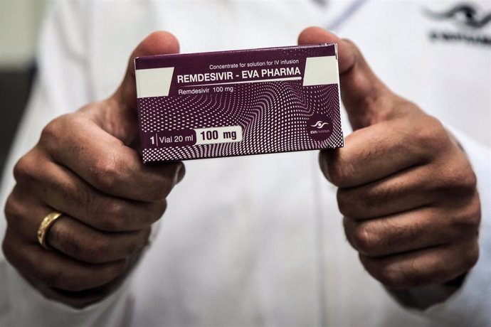 29 June 2020, Egypt, Giza: An employee of Egyptian pharmaceutical company Eva Pharma holds a pack containing vials of Remdesivir, a broad-spectrum antiviral medication approved as a specific treatment for COVID-19, at the company's factory, which starte
