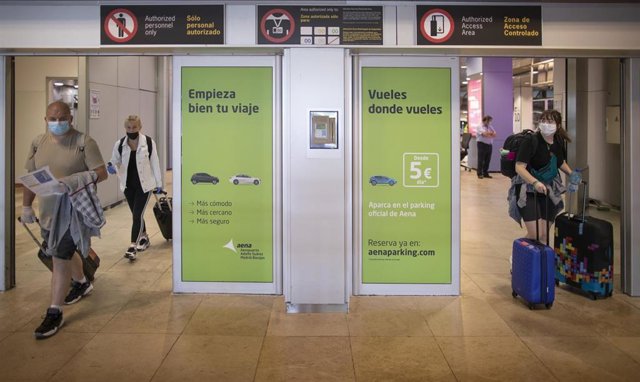 Varias personas protegidas con mascarillas salen de la Terminal T1 del Aeropuerto Adolfo Suárez Madrid-Barajas 