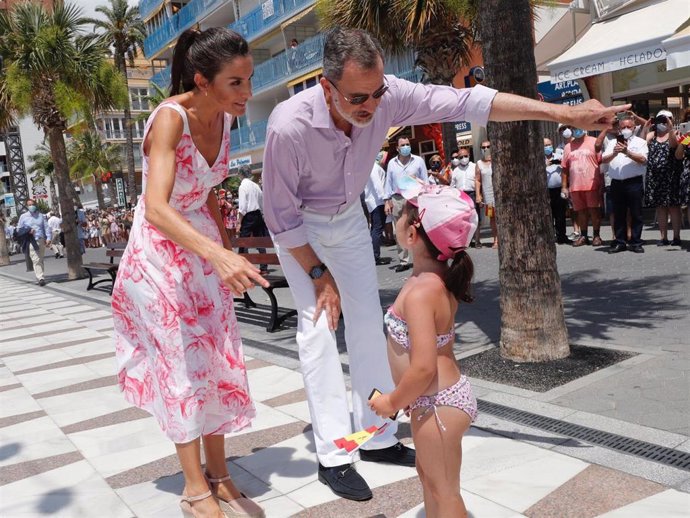 Los Reyes conversan con una niña durante su visita a Benidorm, enmarcada durante el tour que están llevando a cabo por todo el país