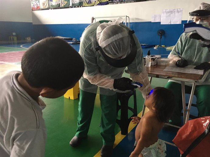 Una enfermera pasando revisión a indígenas warao en Manaus