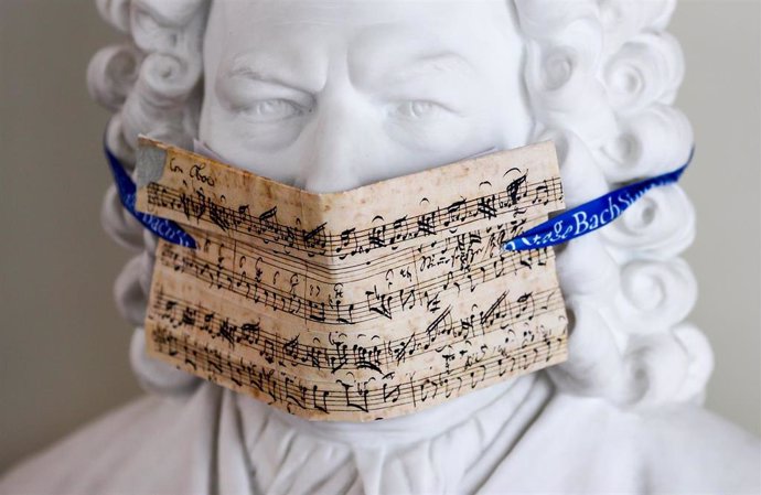 12 May 2020, Leipzig: A bust of Bach with a face mask made of notes from the cantata "My heart swims in blood" is on display in the Bach Archive in front of the exhibition "Bach and Beethoven. Photo: Jan Woitas/dpa-Zentralbild/dpa