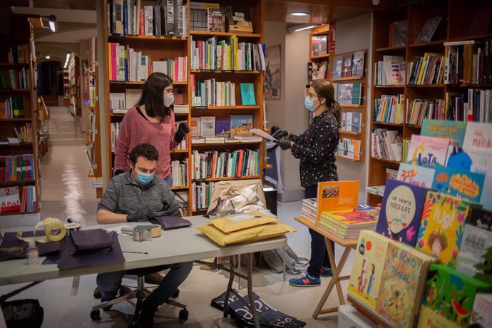 Trabajadores de la librería Laie Pau Claris librería-café ubicada en la calle catalana de Pau Claris, preparan libros y material antes de enviarlos. En Barcelona, Cataluña, (España), a 22 de abril de 2020 (archivo)