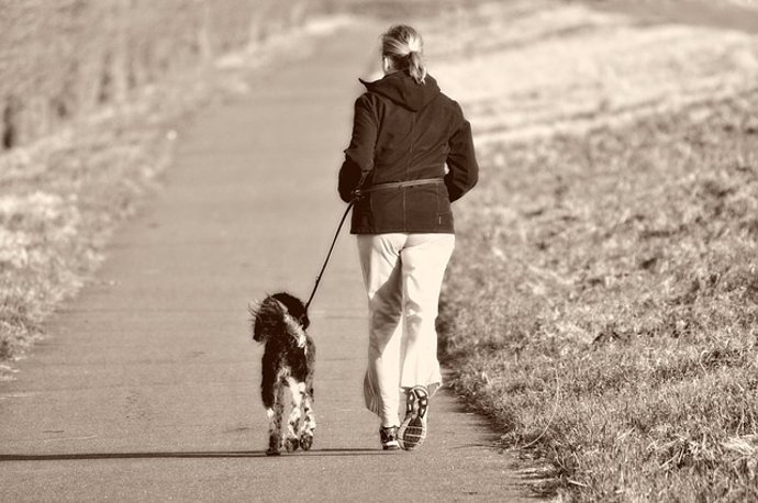 Una mujer hace ejercicio y pasea a su perro, running.
