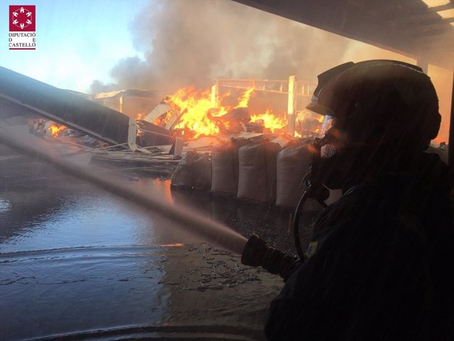 Bombero trabaja en la extinción de un incendio en una nave industrial