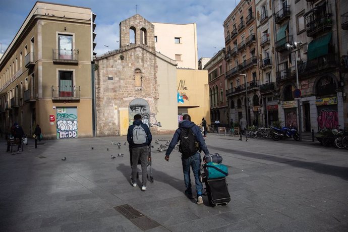 Dos hombres en el barrio del Raval durante la jornada en la que en que se cumplen 20 días desde que se decretó el estado de alarma decretado por el Gobierno a consecuencia del coronavirus, en Barcelona(Catalunya, España), a 2 de abril de 2020.