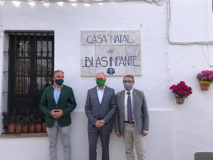 El consejero de Presidencia, Elías Bendodo; el alcalde de Casares, José Carrasco y el presidente de la Diputación de Málaga, Francisco Salado, en la puerta de la casa natal de Blas Infante.