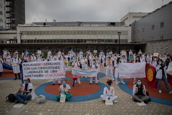 Miembros del personal sanitario protegidos con mascarilla sostienen carteles durante la concentración de sanitarios en el Día Internacional de la Enfermería a las puertas del Hospital Vall d'Hebron, en Barcelona (Catalunya, España), a 12 de mayo de 2020.