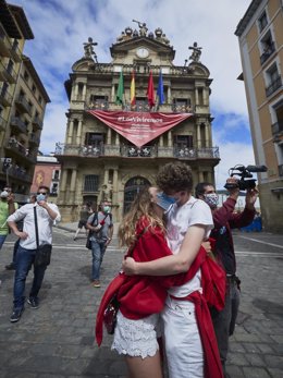 Una pareja con mascarillas se besa en la plaza Consistorial de Pamplona este 6 de julio de 2020 en el día en que deberían haber comenzado los Sanfermines, suspendido por la pandemia de Covid-19.