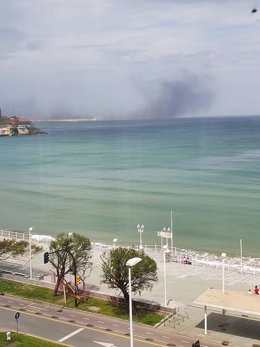 Nube de polvo de carbón procedente de El Musel y visible desde la playa de San Lorenzo