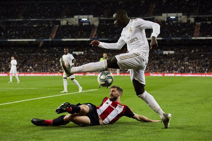 22 December 2019, Spain, Madrid: Real Madrid's Ferland Mendy (R) and Bilbao's Yeray Alvarez battle for the ball during the Spanish Primera Division soccer match between Real Madrid and Athletic Bilbao at Santiago Bernabeu Stadium