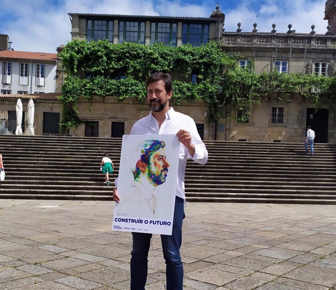 El candidato a la Presidencia de la Xunta por la coalición Galicia En Común-Anova Mareas, Antón Gómez-Reino, posa en la praza da Quintana de Santiago con un cartel con su imagen