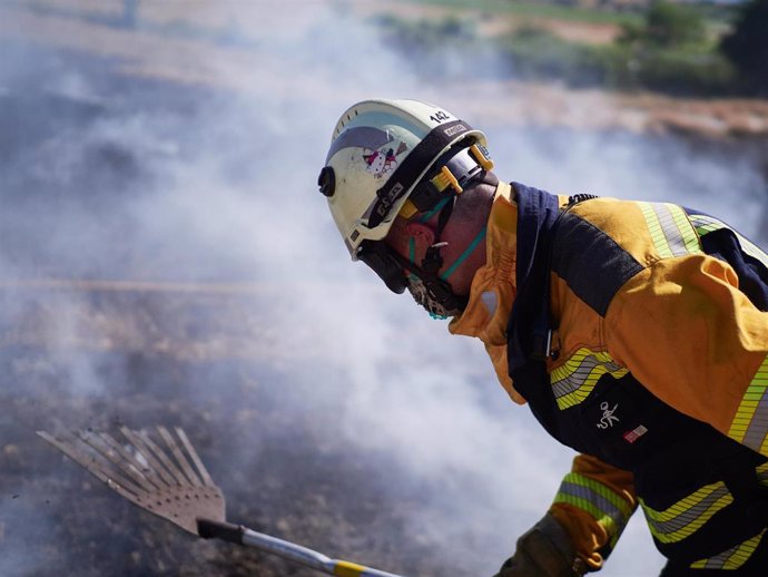 Un bombero realiza labores de extinción de un incendio forestal producido en una zona de campo de cereal, sin afectar a zonas urbanas, cerca de la localidad navarra de Sarriguren, a 21 de junio de 2020.