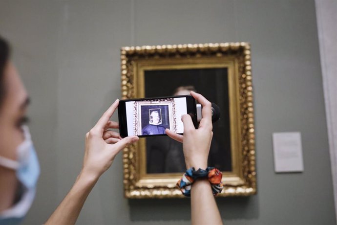 Una visitante saca una foto con el móvil a un cuadro del Museo Nacional del Prado, en el primer día en el que abre sus puertas. En Madrid (España) a 6 de junio de 2020.