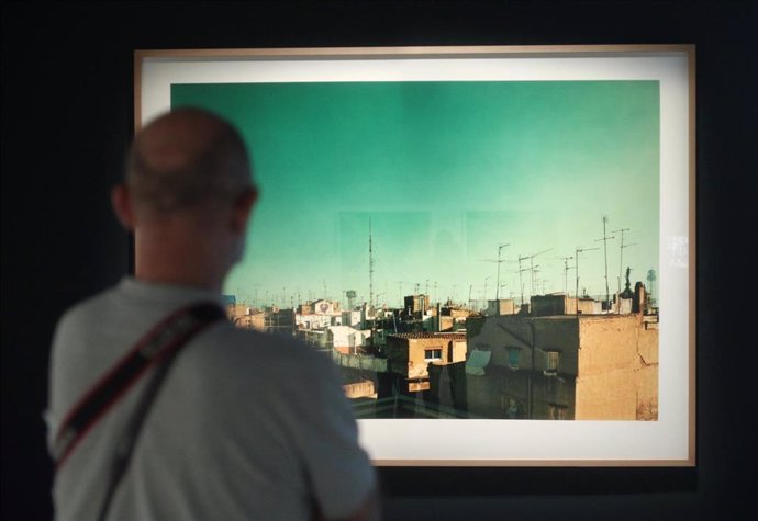 Un visitante observa la fotografía de Hannah Collins 'Historias verdaderas I', una de las obras que componen la exposición Cámara y Ciudad. La vida urbana en la fotografía y el cine.