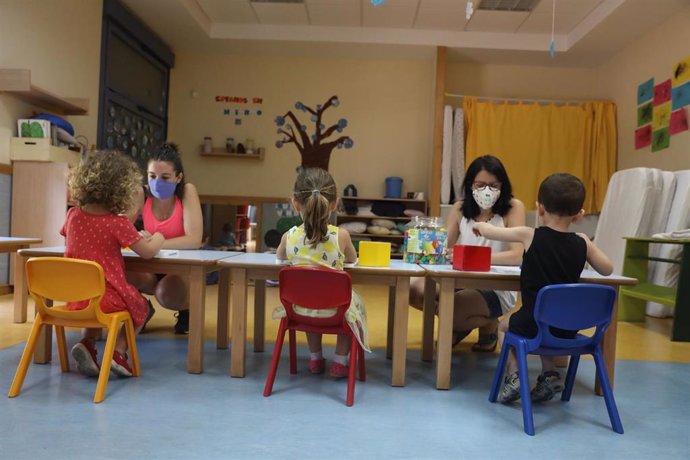 Dos docentes imparten clases a varios alumnos en una escuela infantil