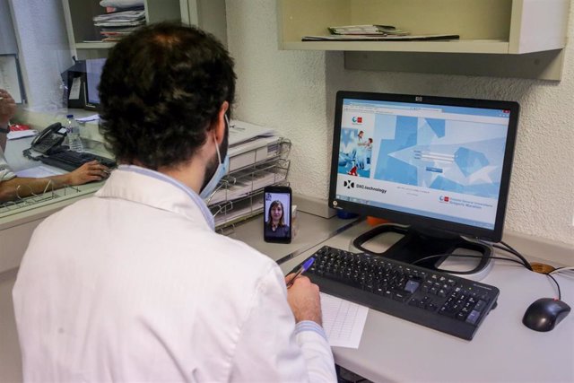 Un farmacéutico habla con una paciente por videollamada para comprobar qué medicación necesita 