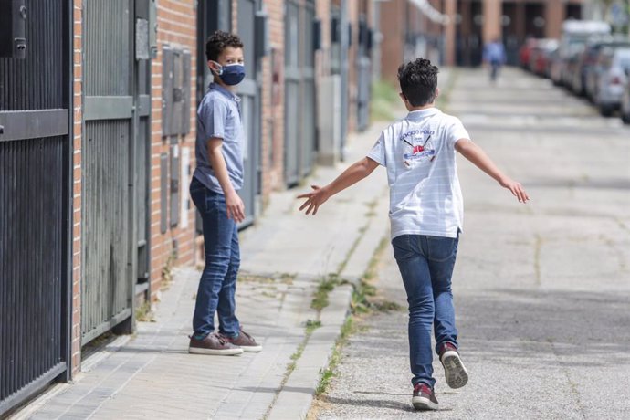 Dos hermanos pasean por la calle durante la pandemia, a 7 de mayo de 2020.