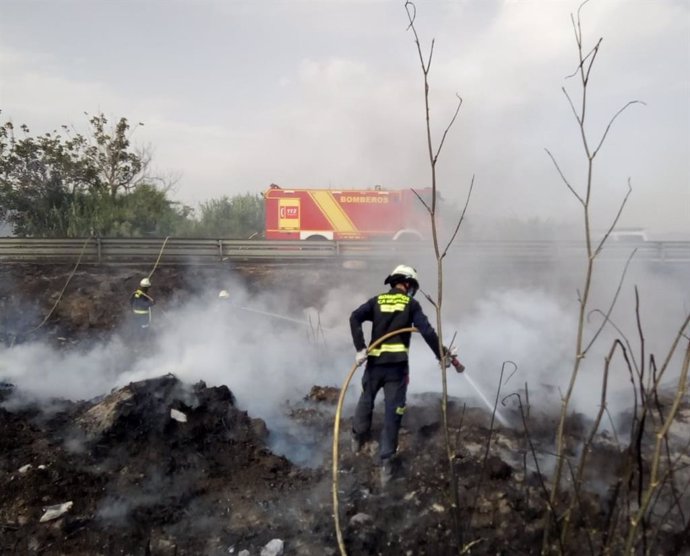 Los bomberos combaten el fuego en un cañaveral de Torrenueva Costa (Granada)