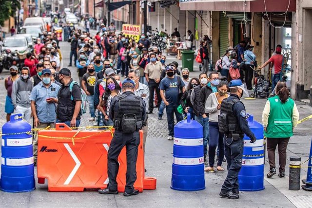 Decenas de personas gurdan la vez para poder acceder a las tiendas de un barrio de Ciudad de México, en medio de la desescalada de las medidas de confinamiento decretadas por la crisis sanitaria de la COVID-19.