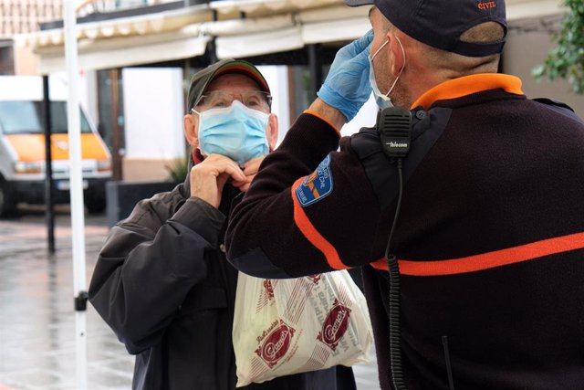 Un hombre recibe indicaciones sobre cómo colocarse la mascarilla, en la estación intermodal de Palma.