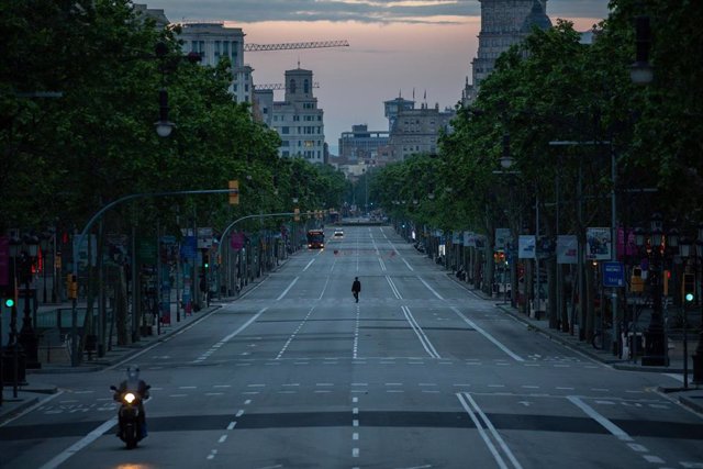 Una persona camina por el Paseo de Grcia de Barcelona que amanece vacío un día marcado por la festividad de Sant Jordi, que a diferencia de otros años, este no se puede celebrar con normalidad debido a la crisis del Covid-19 y al confinamiento al que s