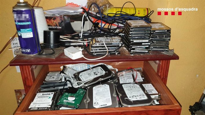 Material incautado al registrar el domicilio del hombre detenido en Vallbona d'Anoia (Barcelona) por presuntamente controlar las cámaras de los ordenadores que arreglaba para tomar fotos y vídeos.