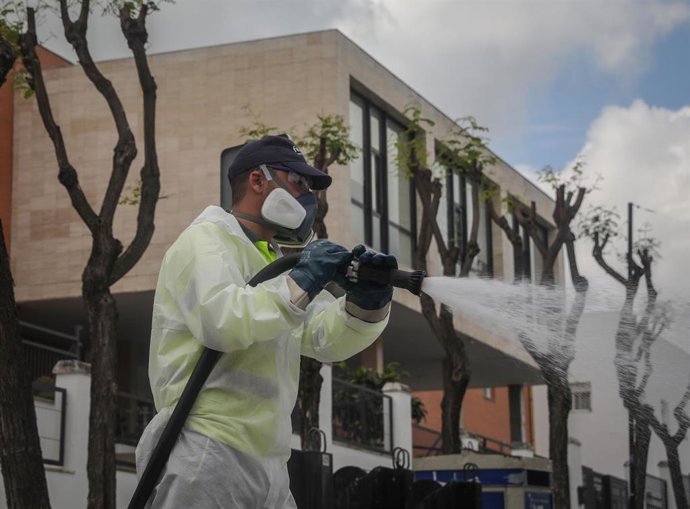 Un operario desinfecta la zona del centro de personas mayores Joaquín Rosillo de San Juan de Aznalfarache
