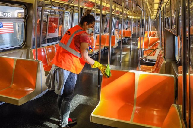 Un trabajador desinfecta asientos del transporte público en Nueva York
